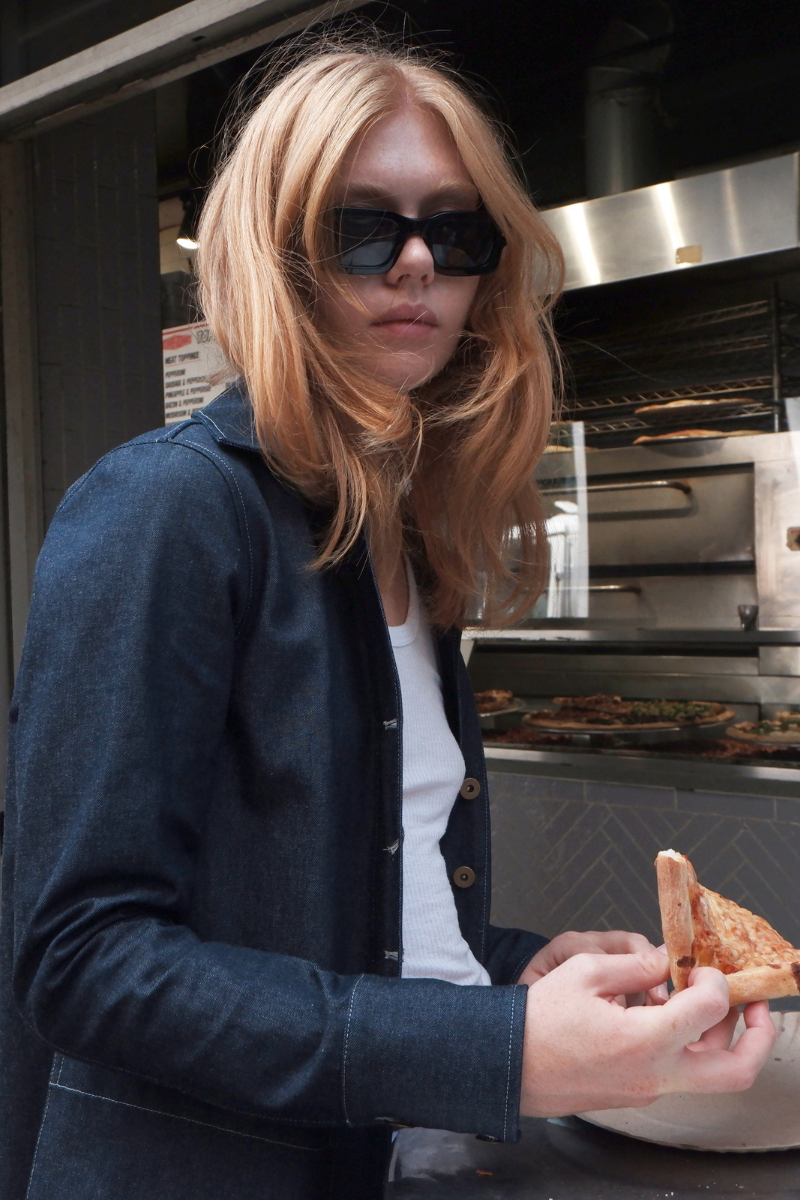 Horizontal shot of Julia eating pizza in the Indigo Gardenia